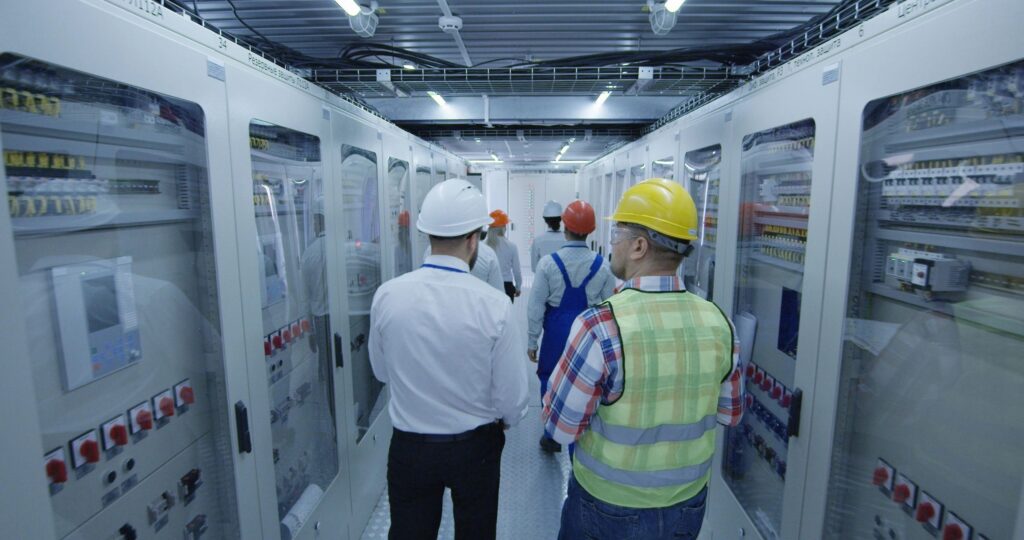Electrical workers walking in the control room