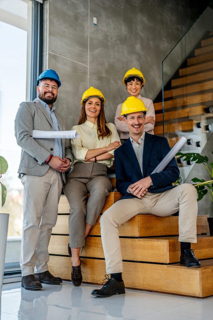 Diverse construction team wearing hard hats and holding blueprints