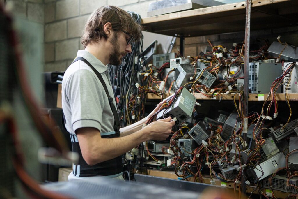 male resource recovery specialist checking computer components conditions
